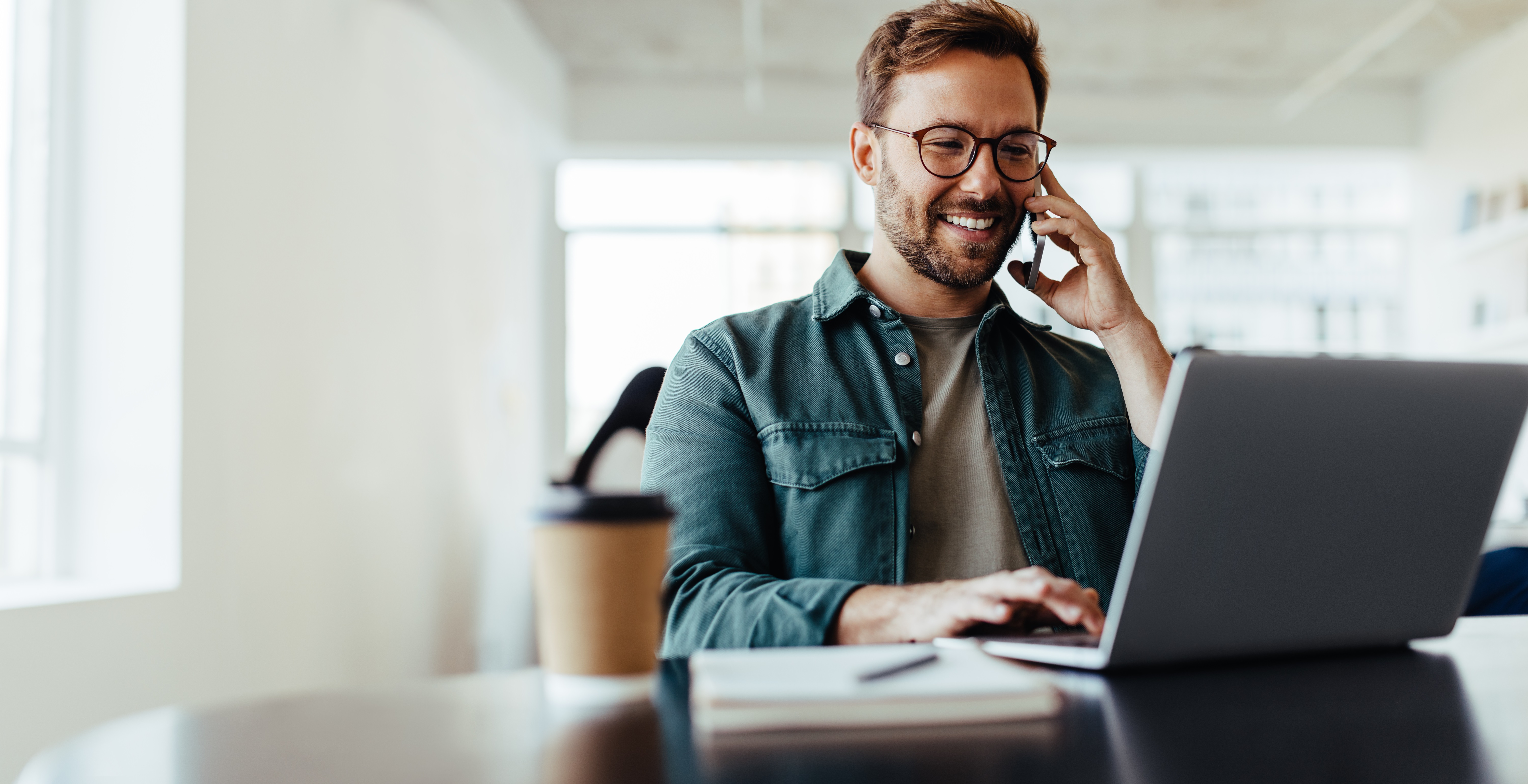 Man Working At Home On Phone And Laptop