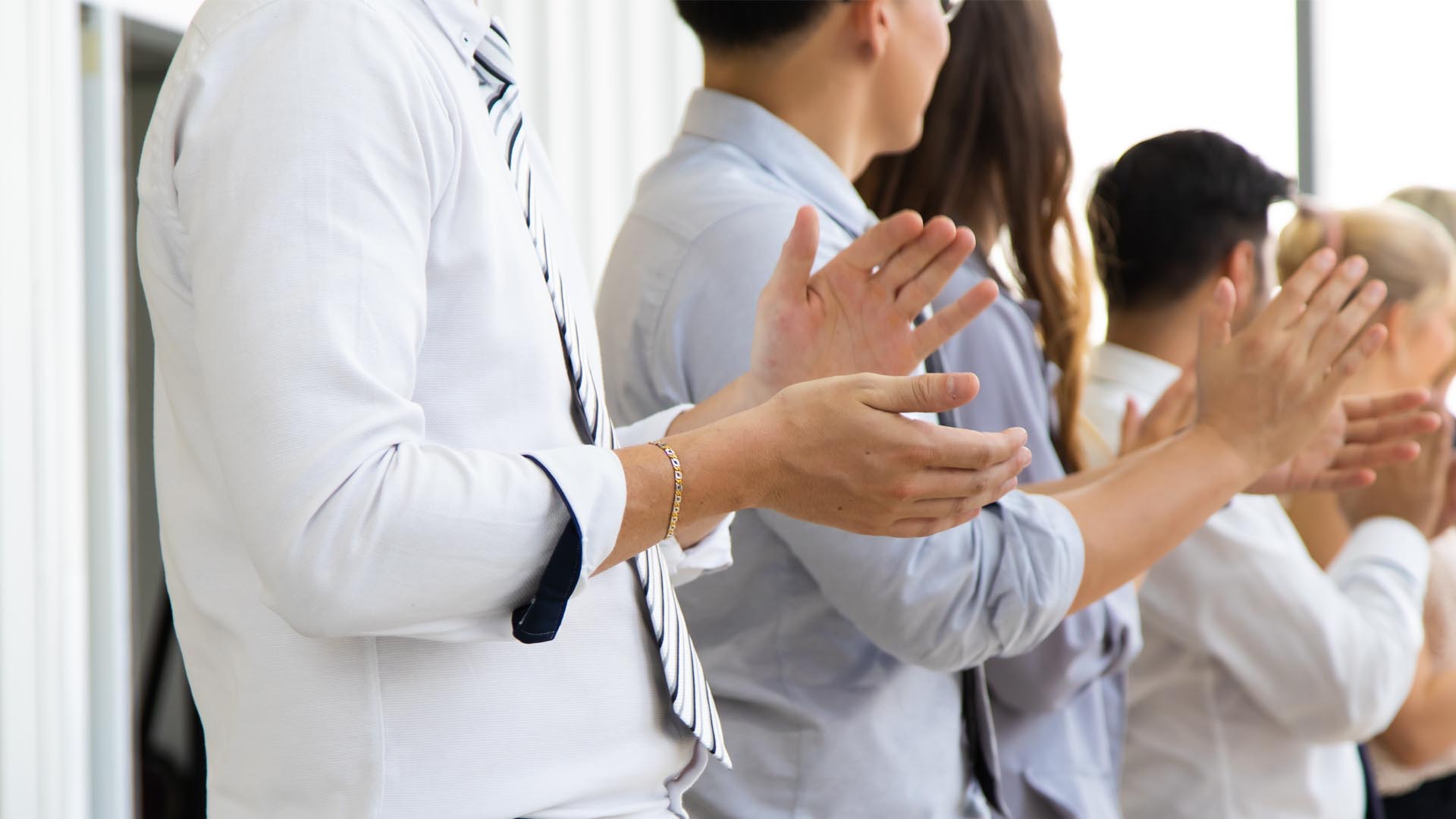 Group of professional women and men clapping