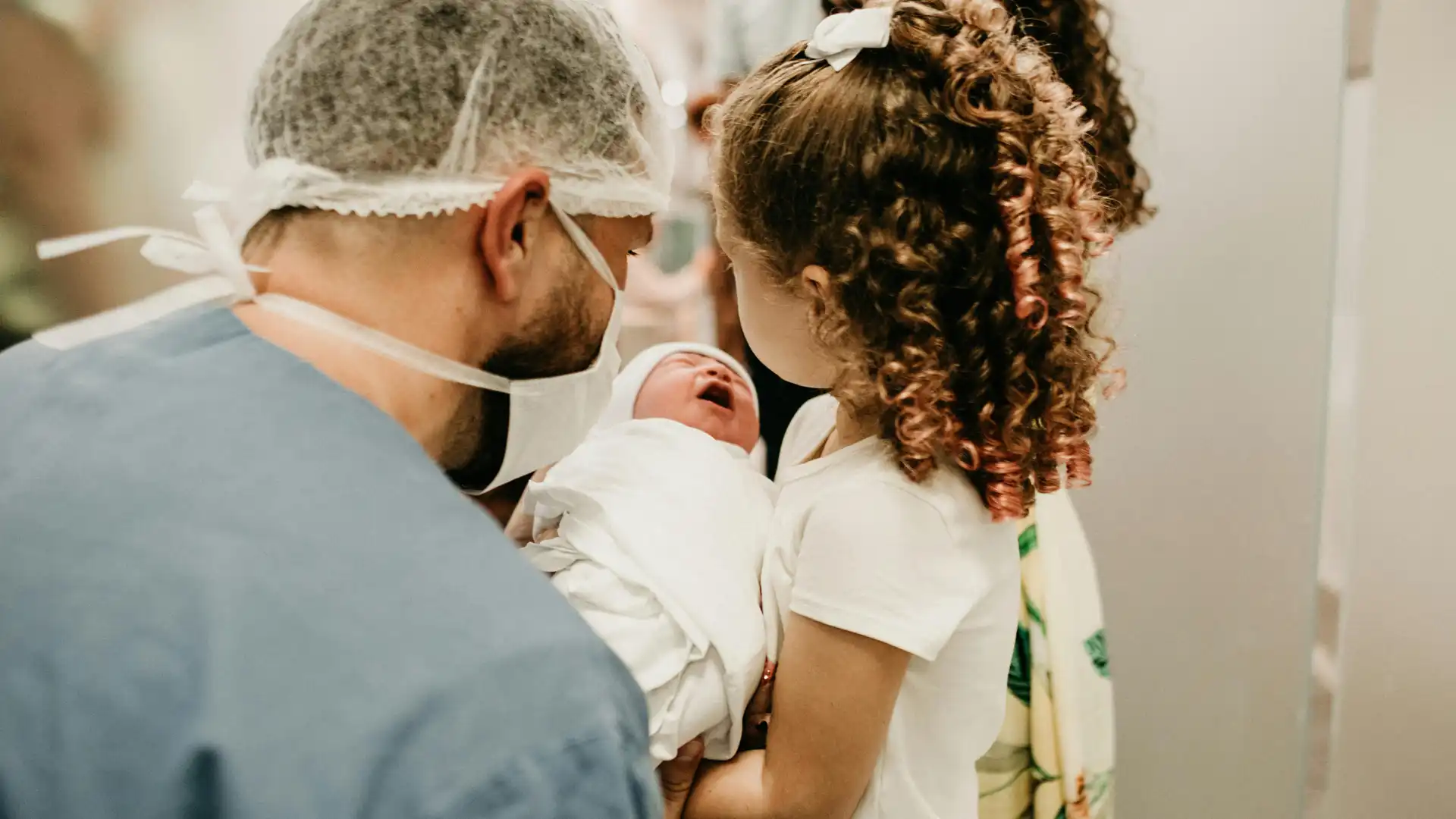Doctor and young girl looking at newborn baby