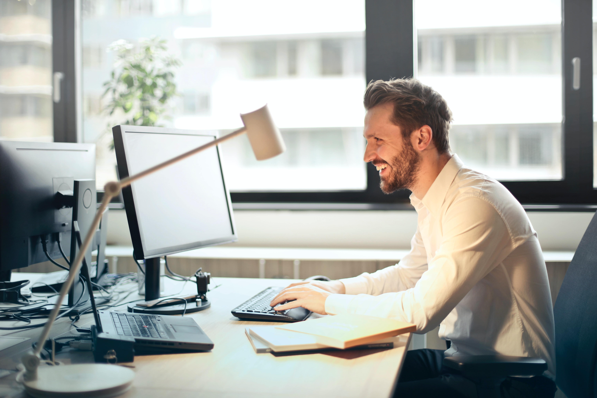 Man In Office smiling at computer screen