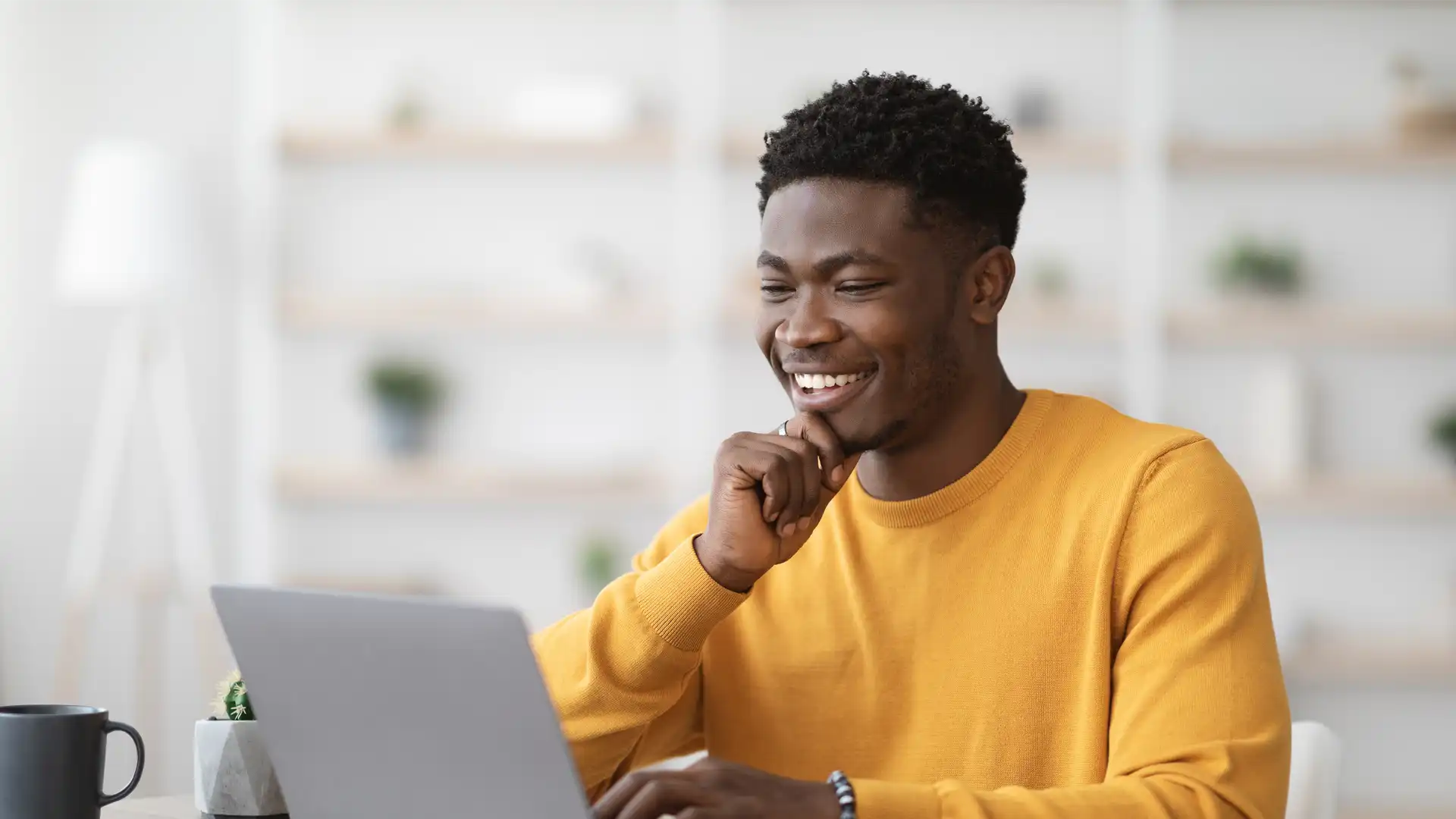 man smiling whilst working on lapop