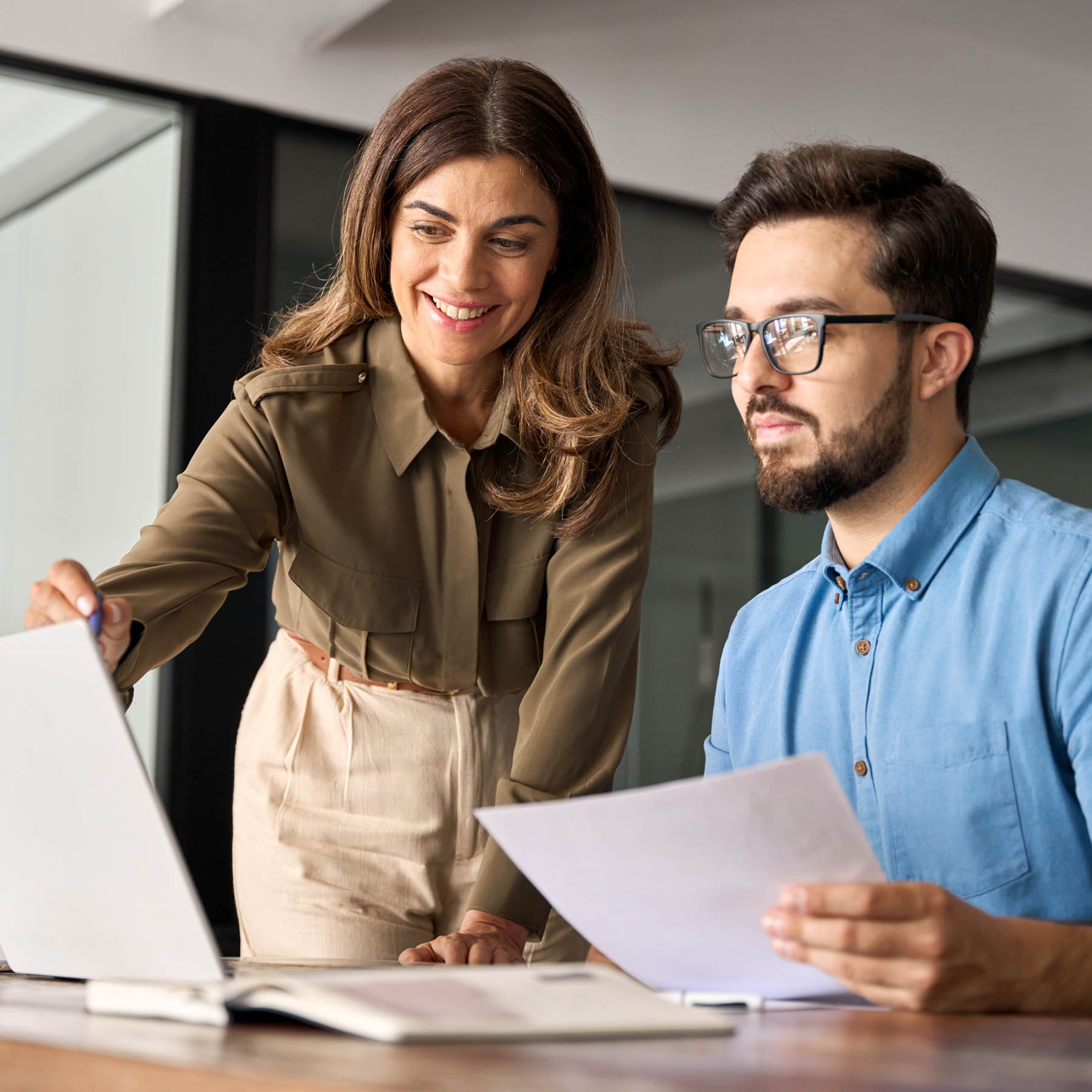 Male and Female colleague on laptop smiling