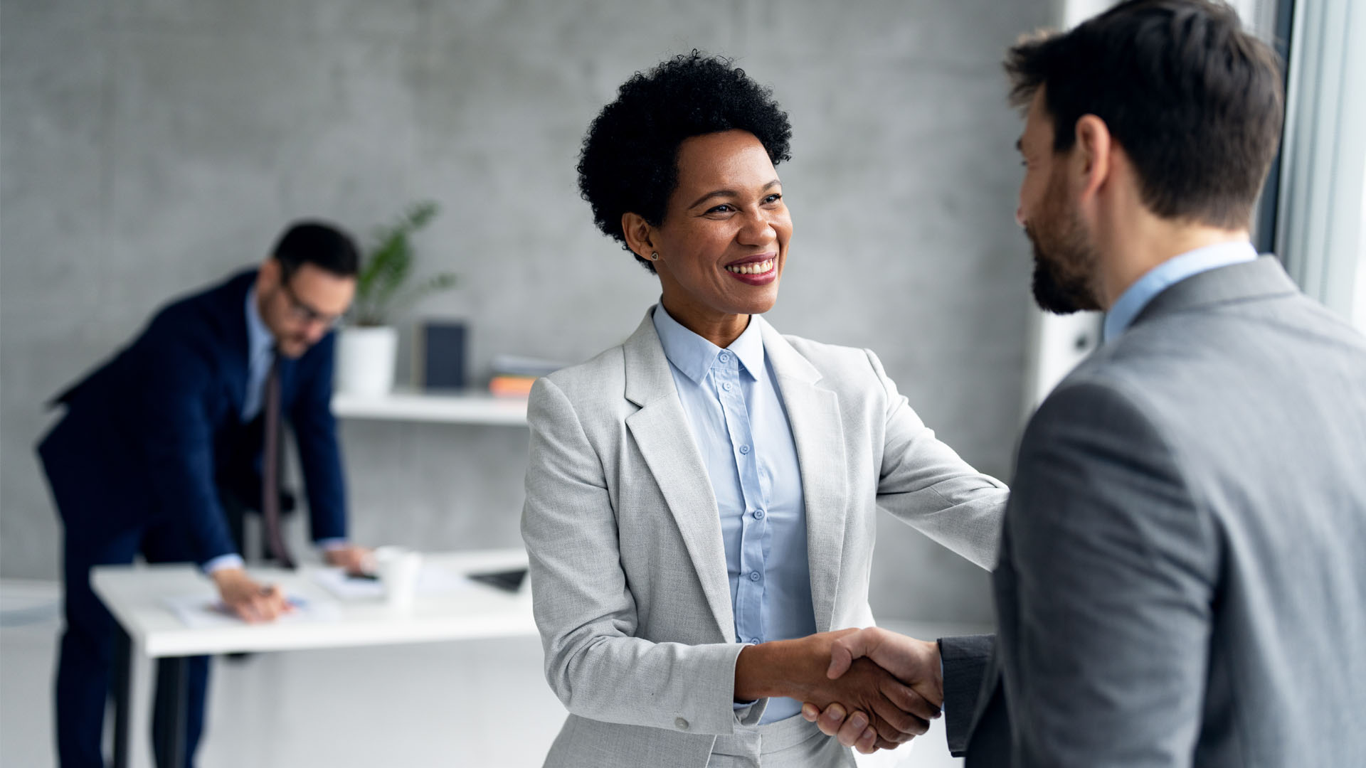 Male and Female colleagues shaking hands smiling
