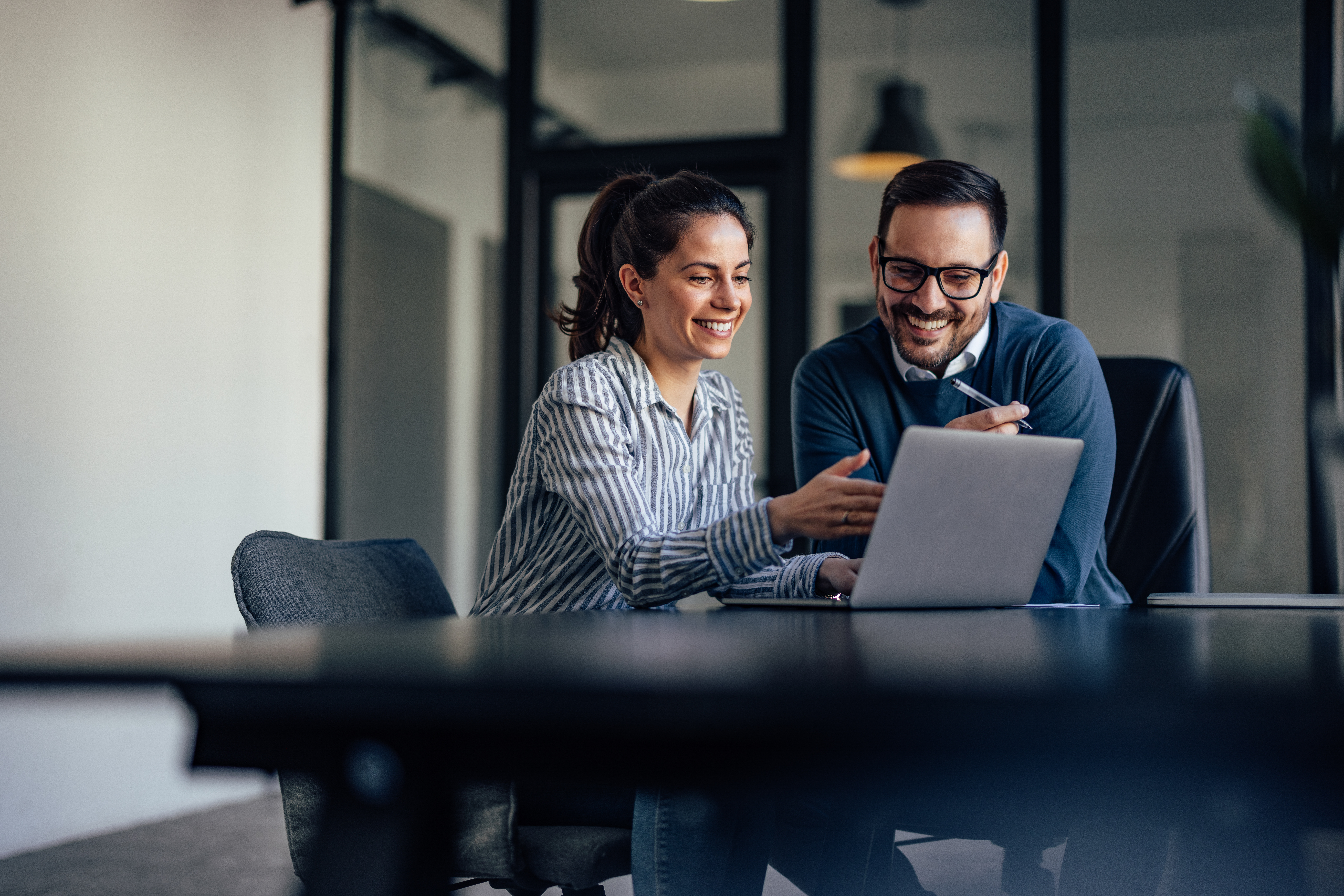 Two People Smiling At Chatbot On Laptop